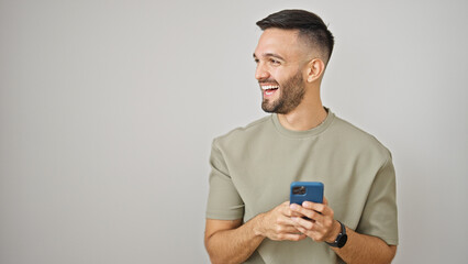 Young hispanic man using smartphone smiling over isolated white background