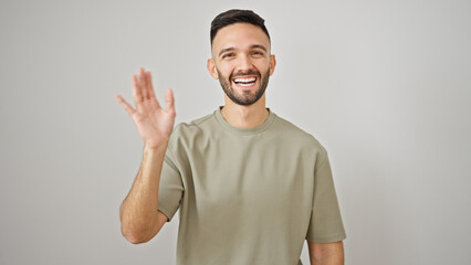 Fototapeta premium Young hispanic man smiling confident saying hello with hand over isolated white background