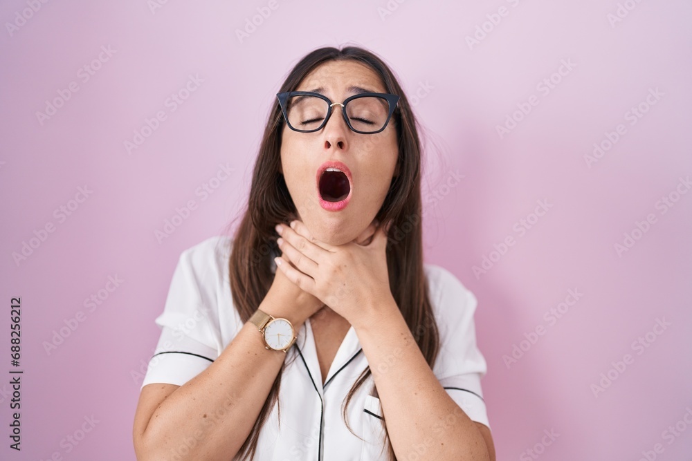 Poster Young brunette woman wearing glasses standing over pink background shouting and suffocate because painful strangle. health problem. asphyxiate and suicide concept.