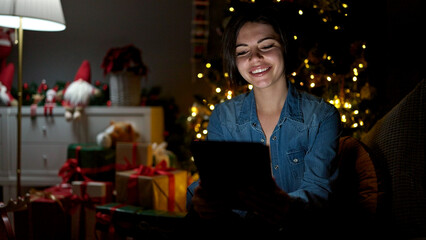 Young caucasian woman using tablet sitting on the sofa at home