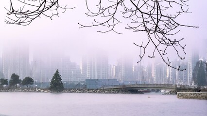 City skyline by water in a foggy morning. Coal Harbour. Vancouver, BC. Canada
