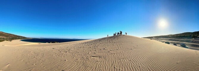 panorama view of a group of tourists on the high sandy dune landscape near Valdevaqueros with a...