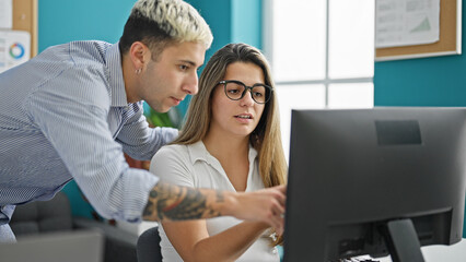 Two workers man and woman working together drinking coffee at the office