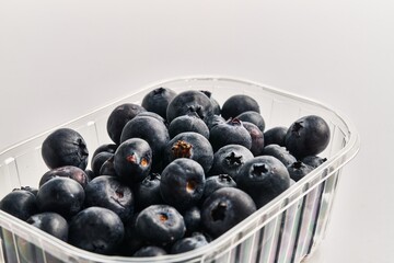  Delicious group of blueberries on plastic box over isolated white background