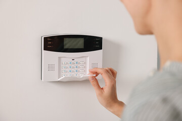Woman entering code on security system, closeup
