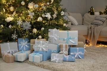 Many gift boxes under decorated Christmas tree in room
