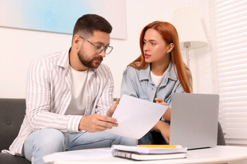 Couple doing taxes at table in living room