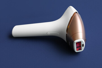 Modern photoepilator on dark blue background
