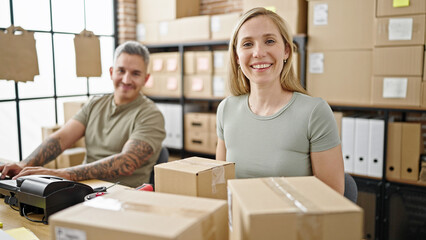 Man and woman ecommerce business workers sitting together smiling at office