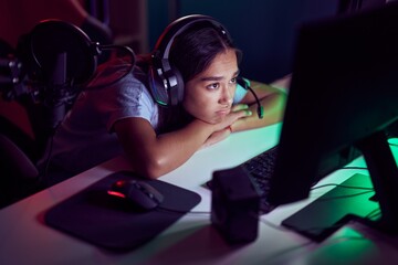 Young beautiful hispanic woman streamer stressed using computer at gaming room