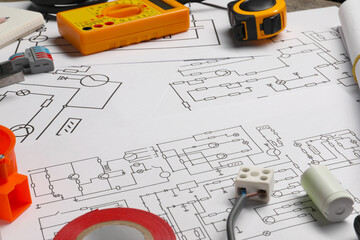 Digital multimeter and other electrician's equipment on wiring diagrams