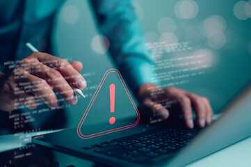 Businessman or it staffs, programmer, developer using computer laptop with triangle caution warning sign for notification error and maintenance concept. Virus detected warning, Cybercrime protection