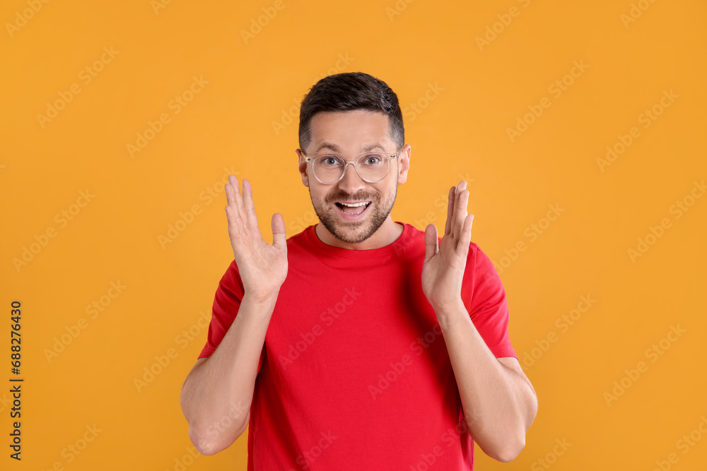 Poster Portrait of emotional man in stylish glasses on yellow background