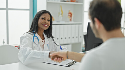 Doctor and patient having medical consultation shaking hands at the clinic