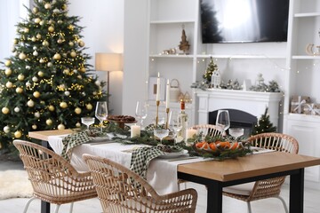 Christmas table setting with festive decor and dishware in living room