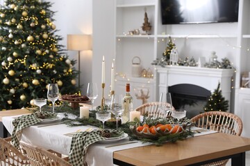 Christmas table setting with festive decor and dishware in living room