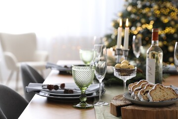 Christmas table setting with festive decor and dishware in room