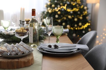 Christmas table setting with festive decor and dishware in room