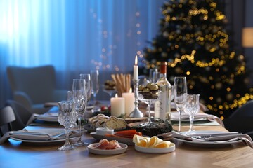Christmas table setting with festive decor and dishware in room