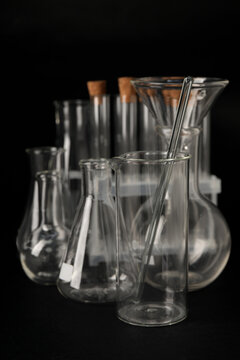 Different laboratory glassware on black background, closeup