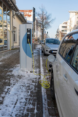 An electric car on the street is being charged in Germany. Electric car in charging station,...