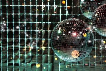 Shiny disco balls against foil party curtain under color lights, space for text. Bokeh effect