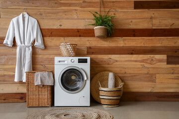 Laundry room interior with washing machine, wicker basket and bathrobe