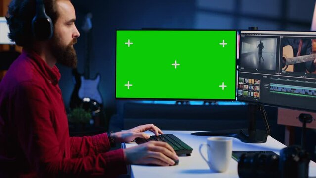 Videographer using professional software on chroma key PC to create visual effects for video projects. Expert using post production techniques to edit raw clips footage on isolated screen monitor