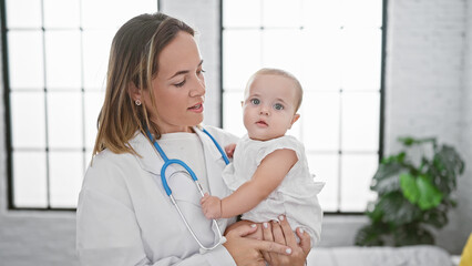 Doctor holding baby on arms at home