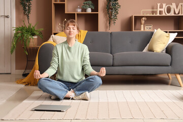 Young woman meditating on floor at home