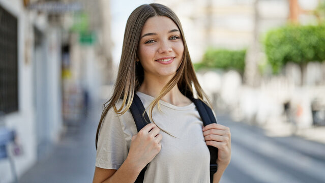 Young beautiful girl student smiling confident wearing backpack at street