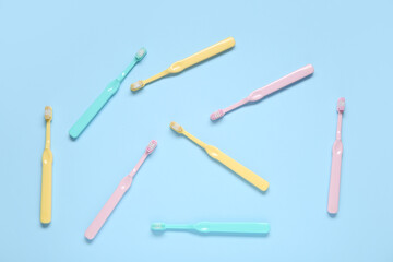 Colorful toothbrushes on blue background.