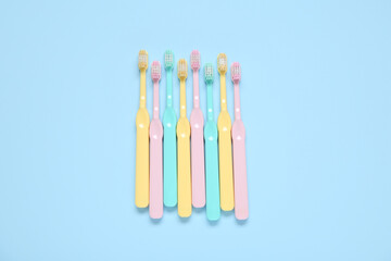 Colorful toothbrushes on blue background.