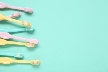 Colorful plastic toothbrushes on color background.