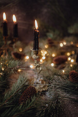 Christmas dark academia vintage winter wooden table with fir branches, pine cones, black candles...
