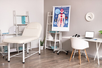 Interior of medical office with workplace, couch and shelf units