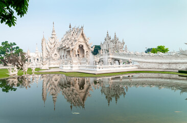 Wat Rong Khun,the White Temple at dawn,and surrounding pond,outskirts of Chiang Rai,Northern Thailand. - obrazy, fototapety, plakaty