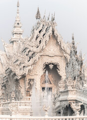 Sun shines on Wat Rong Khun,fantastical White Temple and fountain at dawn,outskirts of Chiang Rai ,Northern Thailand.