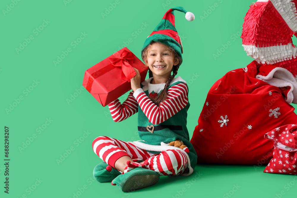 Canvas Prints Cute little elf with Christmas gift and Santa bag on green background