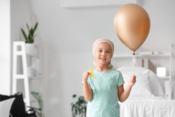 Little Asian girl after chemotherapy with ribbon and balloon in clinic. Childhood cancer awareness...