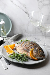 Seafood. Delicious baked fish served with orange and microgreens on light table