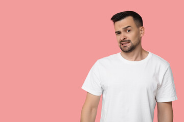 Obraz premium Handsome worried young man on pink background