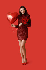 Happy young woman with bouquet of roses and heart shaped air balloon on red background