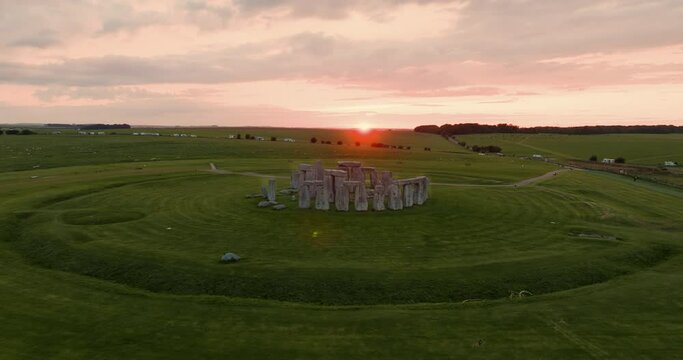Cinematic shot of timeless famous Stonehenge in beautiful bright pink sunset light.