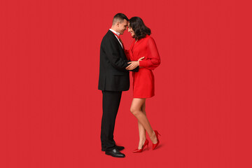 Loving young couple on red background. Celebration of Saint Valentine's Day