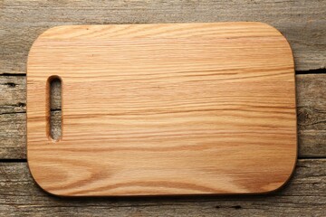 One new cutting board on old wooden table, top view