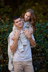 Obraz premium Young Cute Female Hugs Boyfriend. In Autumn Outdoor. Lovers Walking in Park. Attractive Funny Couple. Lovestory in Forest. Man and Woman. Cute Lovers in the Park. Family Concept. Happy Couple.
