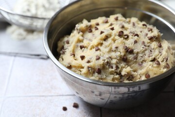 Chocolate chip cookie dough in bowl on table, closeup