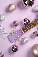 Composition with ukulele and beautiful Christmas decorations on lilac background