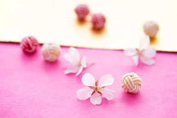 日本の正月イメージ　桜の花と水引玉と和紙のデザイン（ピンクと金色の和紙の背景・12月5日提出）